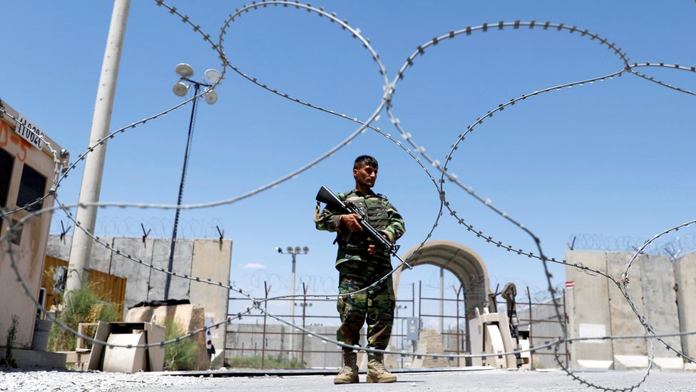 An Afghan National Army soldier stands guard at the gate of Bagram US air base.