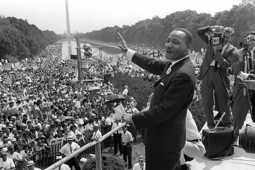 US civil rights leader Martin Luther King, Jr., waves to supporters from the steps of the Lincoln Memorial 28 August, 1963, on The Mall in Washington, DC