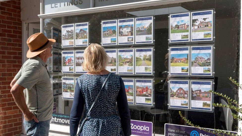 Couple looking at properties in estate agent window