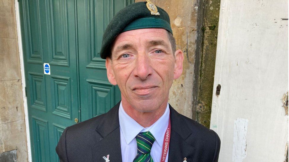 Martin Weathers wearing his cap and medals standing at Bath Railway station