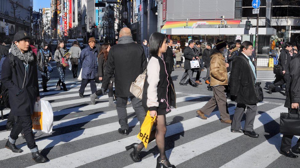 Japanese people cross a street in Shibuya