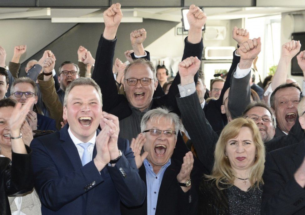Supporters of the conservative Christian Democratic party cheer after the first exit polls are published