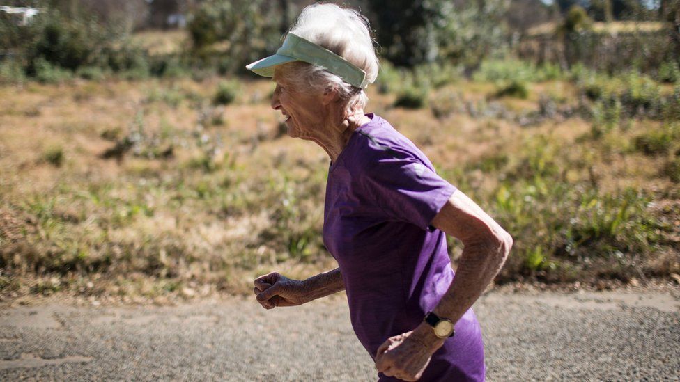 Deirdre Larkin, 86, is seen running in a purple T-shirt.