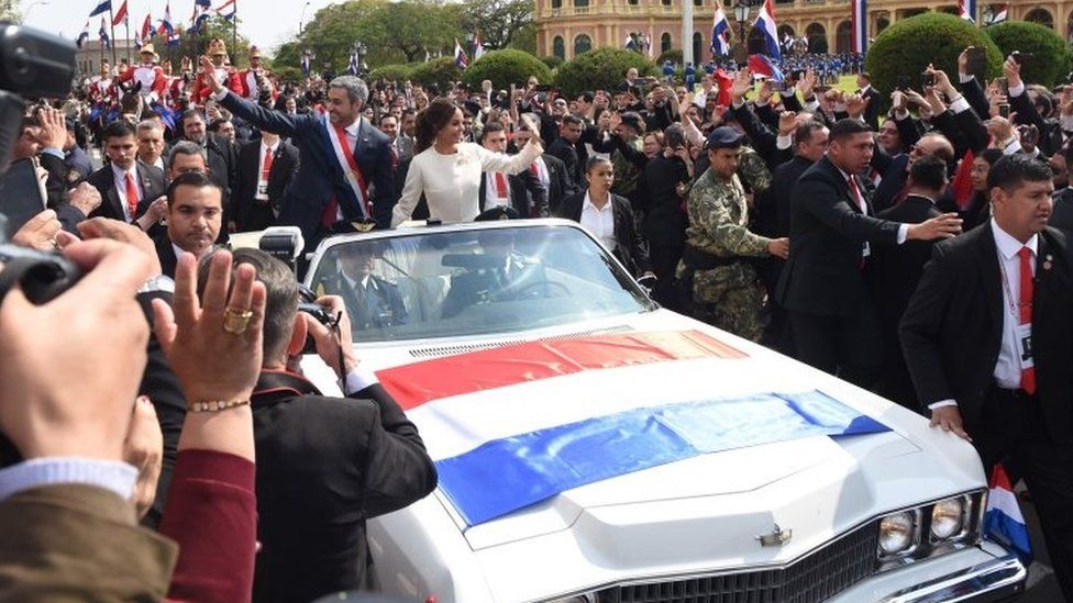 Mario Abdo Benitez and his wife Silvana Lopez wave to the crowds from a 1967 Cadillac convertible after the swearing-in ceremony at the presidential palace in Asuncion.