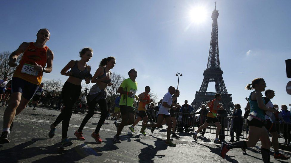 Competitors run past the Eiffel Tower during the Paris Marathon