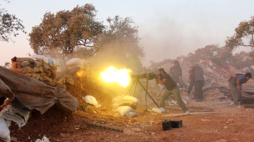 A rebel fighter fires heavy artillery during clashes with government forces and pro-regime shabiha militiamen in the outskirts of Syria's northwestern Idlib province