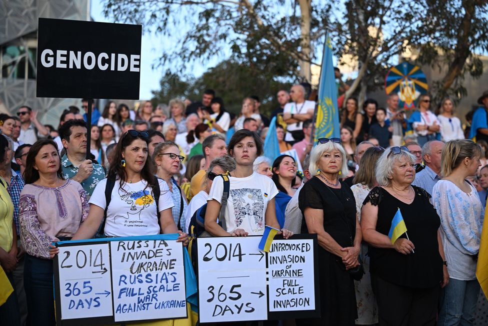 La gente se reúne durante una vigilia con velas para conmemorar el primer aniversario de la guerra en Ucrania en la plaza de la Federación en Melbourne, Australia, 24 de febrero de 2023.
