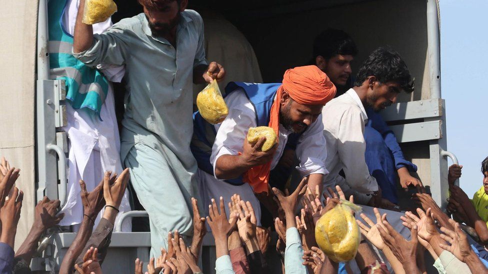 People affected by floods receive aid in Sehwan, Sindh province