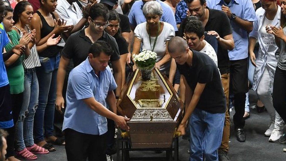 The coffin of one of the victims of the Raul Brasil public school shooting is wheeled by mourners