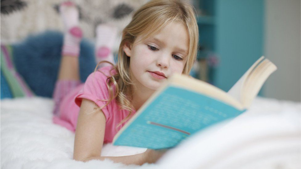 A child reading in bed