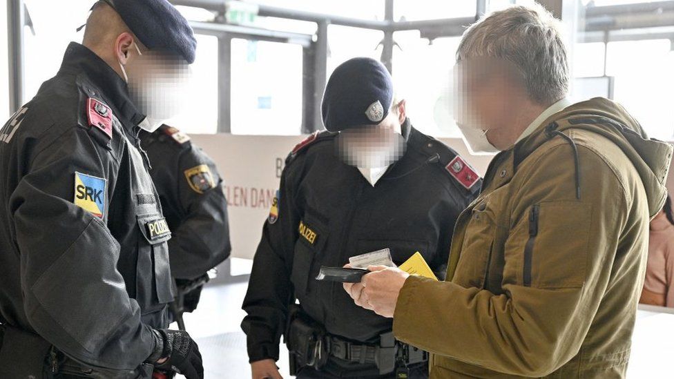 Австрийские полицейские проверяют личность мужчины и справку о вакцинации во время проверки в Фозендорфе, округ Мёдлинг, Австрия, 16 ноября 2021 г.