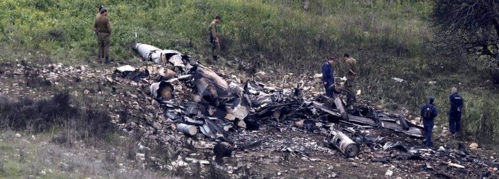 Israeli soldiers inspect the remains of an Israeli F-16 fighter jet that was shot down after being hit by Syrian anti-aircraft fire, in northern Israel, 10 February 2018