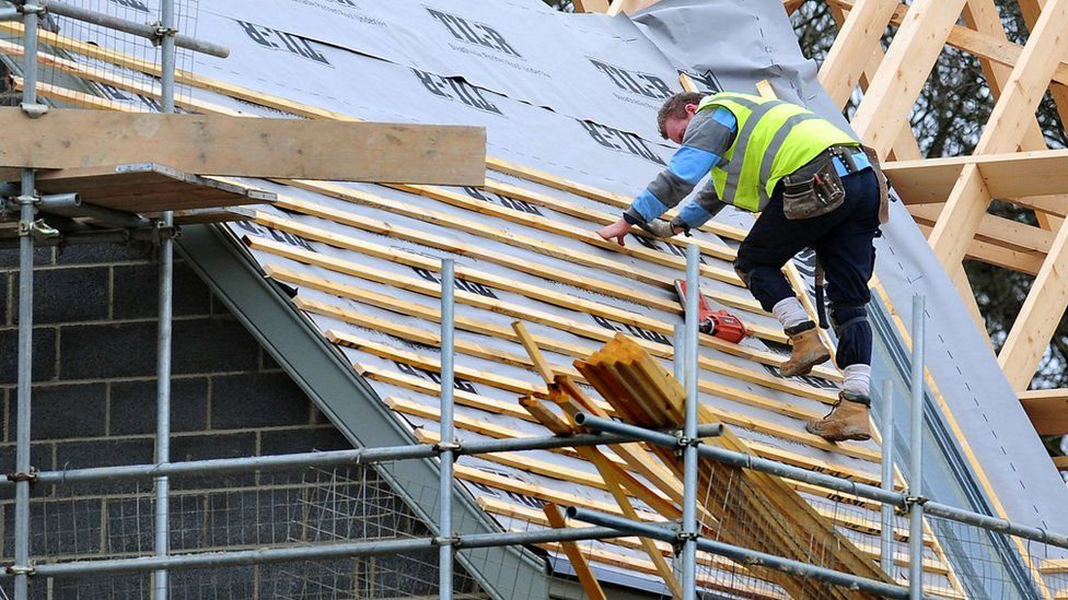 Man on housing roof