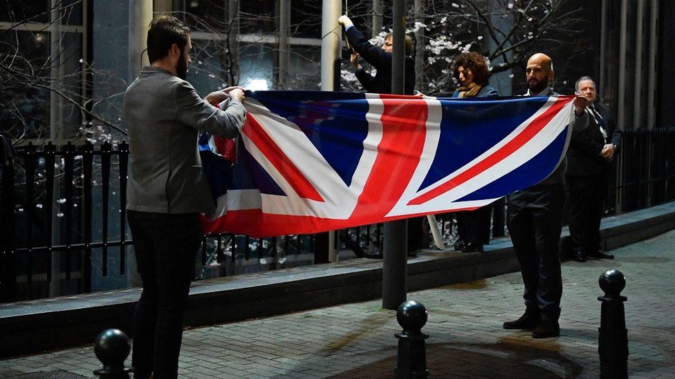 The UK flag is taken down and folded up outside the European Parliament building in Brussels.