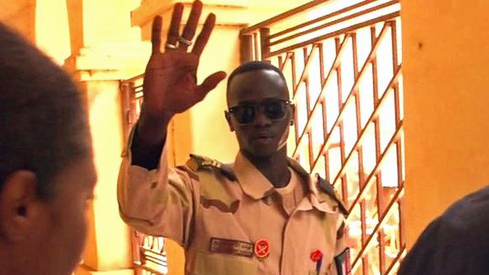 A security man in Sudan waves