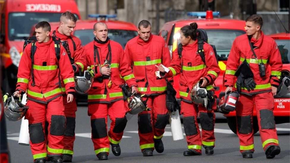 Firefighters walk near Paris police headquarters.