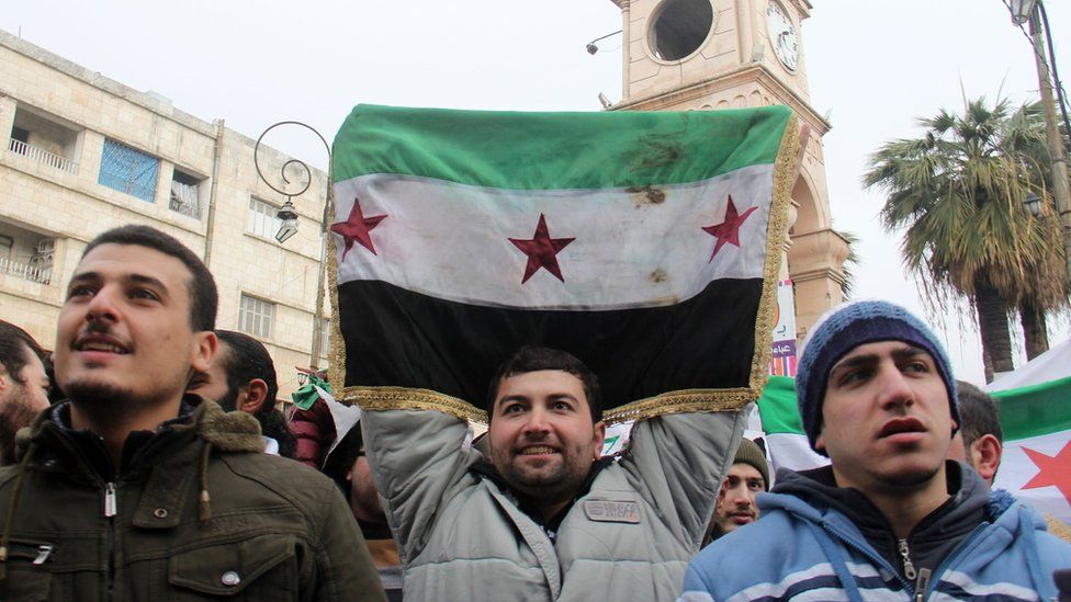 Syrian opposition supporters take part in a a protest calling for the overthrow of Syria's government in the city of Idlib (30 December 2016)