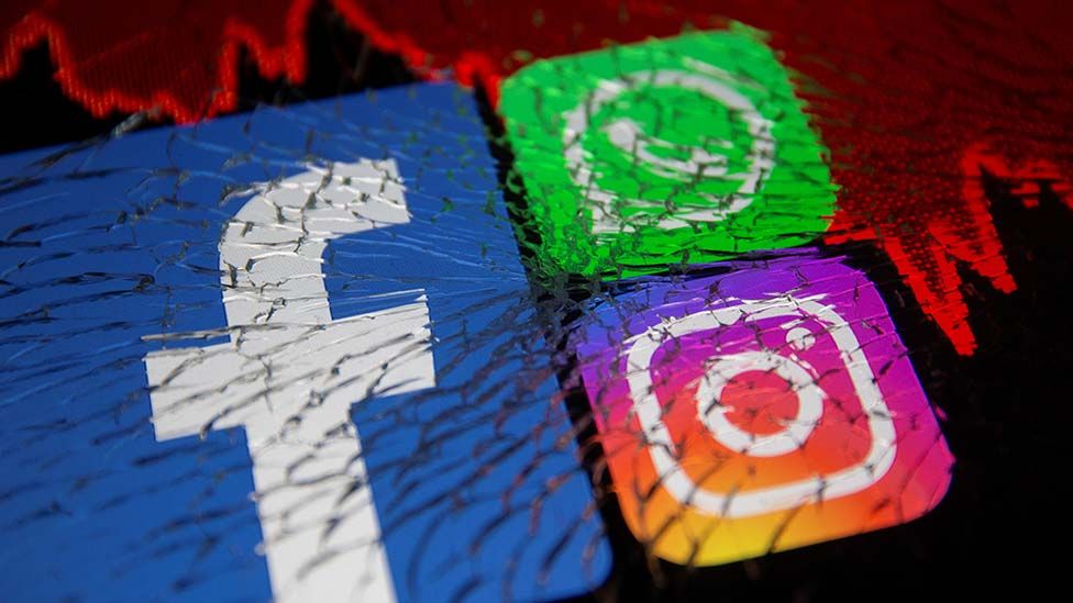 Facebook, Whatsapp and Instagram logos and stock graph are displayed through broken glass