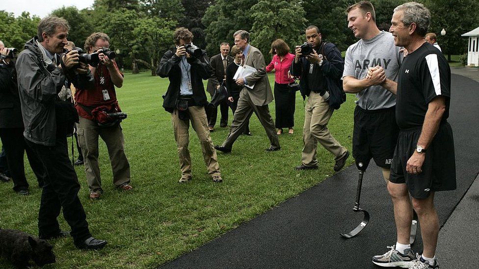 President George W Bush jogs around the White House with wounded veteran Christian Bagge on 2 June 2006