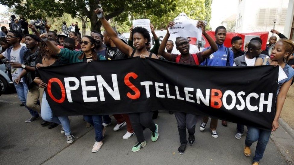 Студенты маршируют с транспарантами во время акции протеста у Стелленбосского университета в Южной Африке в Стелленбосе - 1 сентября 2015 г.