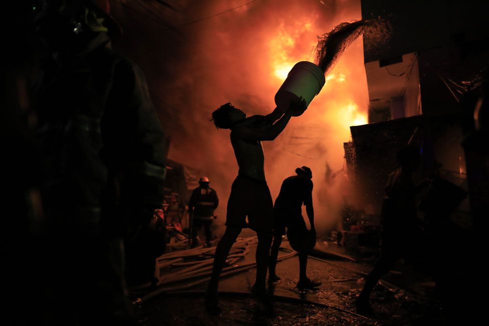 Firefighters and residents try to extinguish a fire in a residential district of Las Pinas city, Metro Manila, Philippines, 01 April 2024