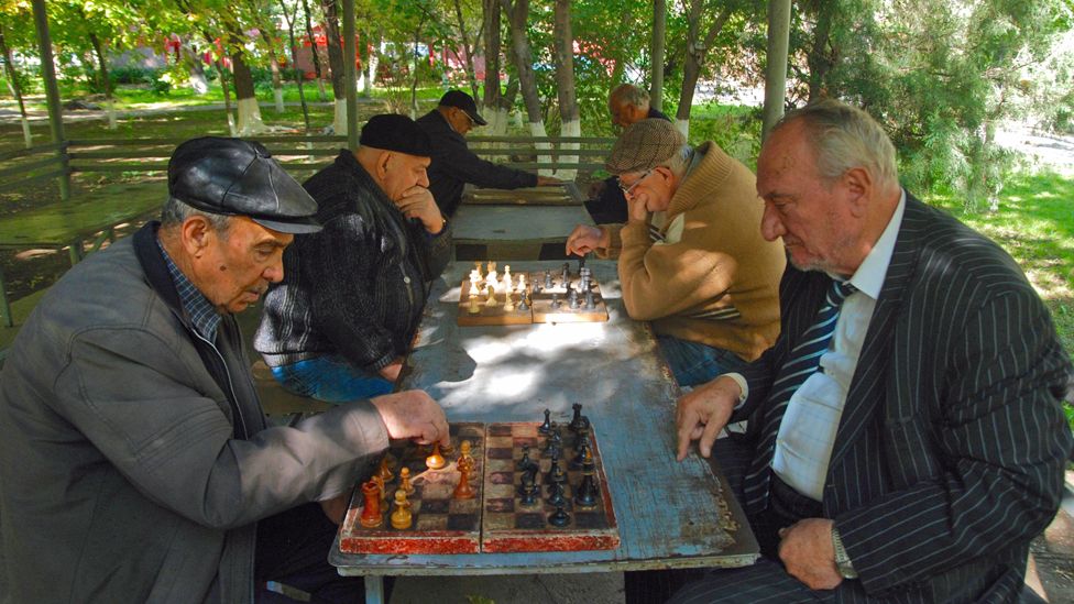 old men playing chess in the park
