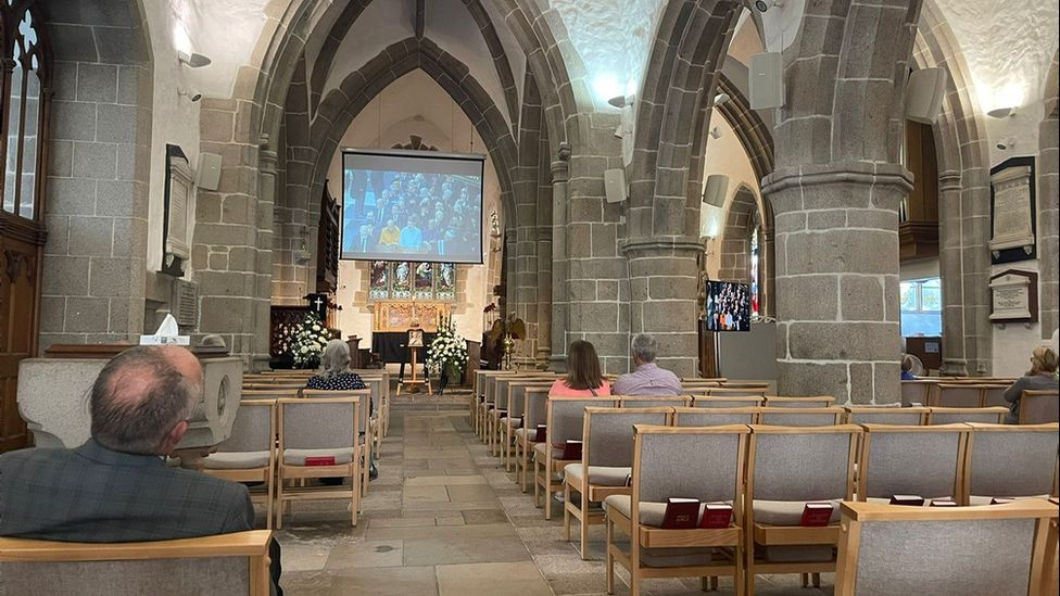 Люди в городской церкви наблюдали за государственными похоронами
