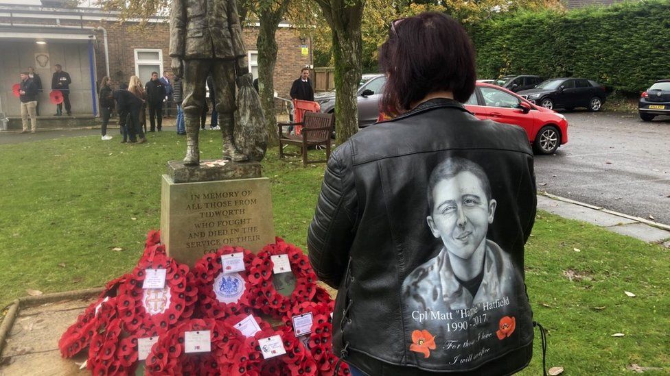 Fran Chandler showing the back of her leather jacket. It is printed with an image of her son and some poppies,
