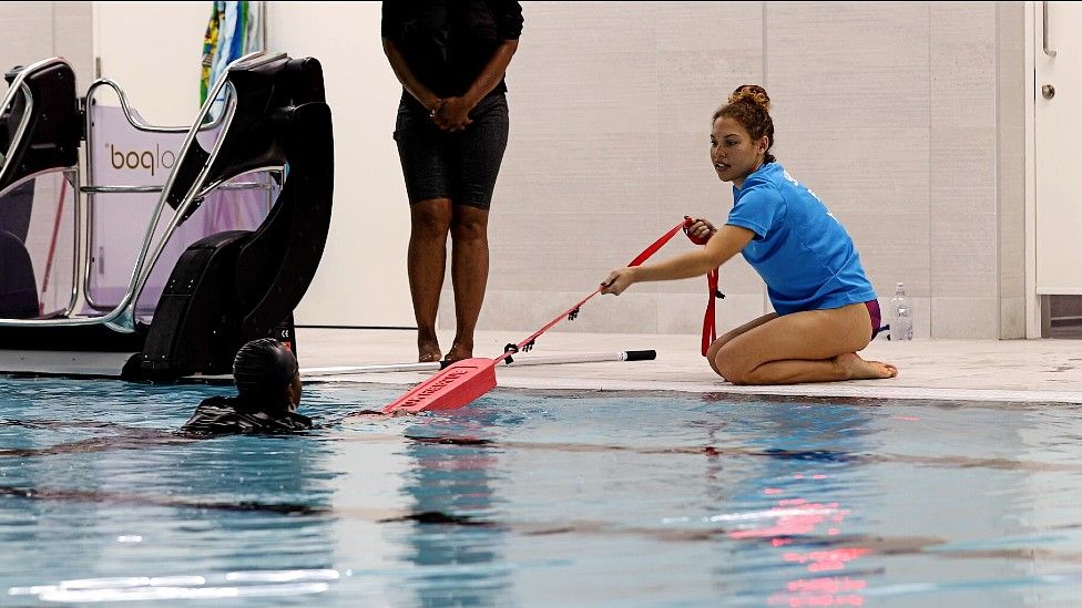 Seren Jones helping a swimmer in a pool