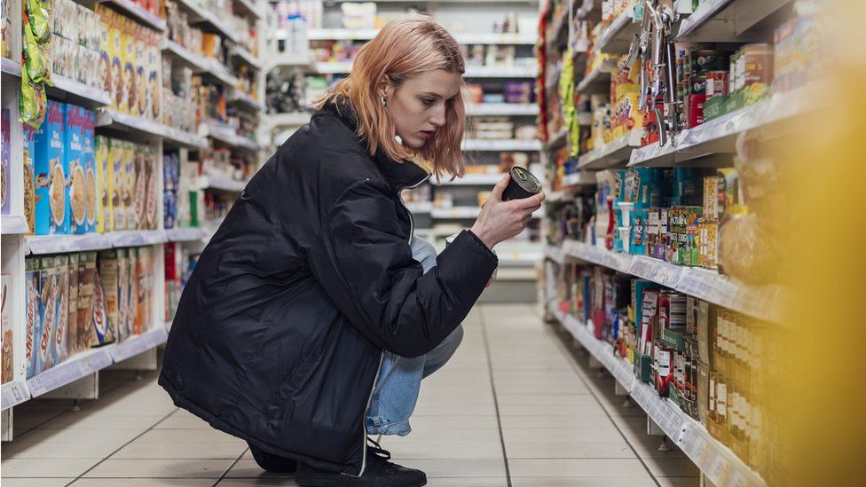 Women looking at food on supermarket shelf