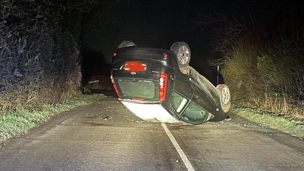 Car ends up on roof after skidding on icy Warwickshire road BBC News