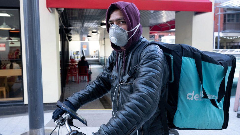 A Deliveroo rider wearing a face mask