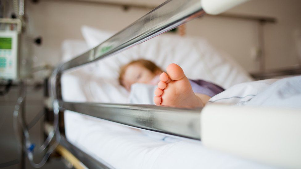 Stock image of a child in a hospital bed