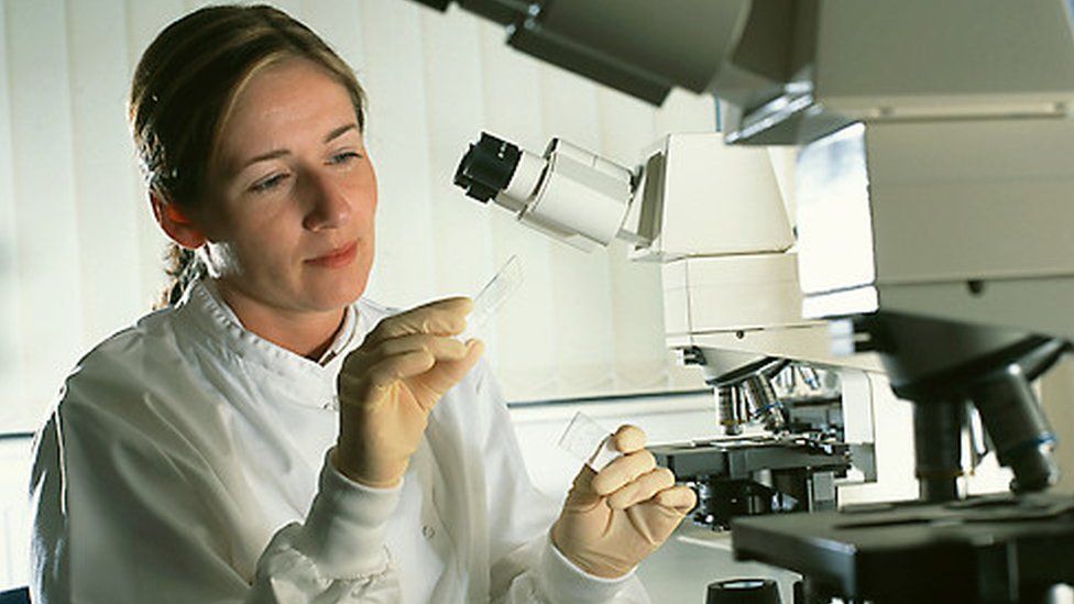 Female scientist studying a slide