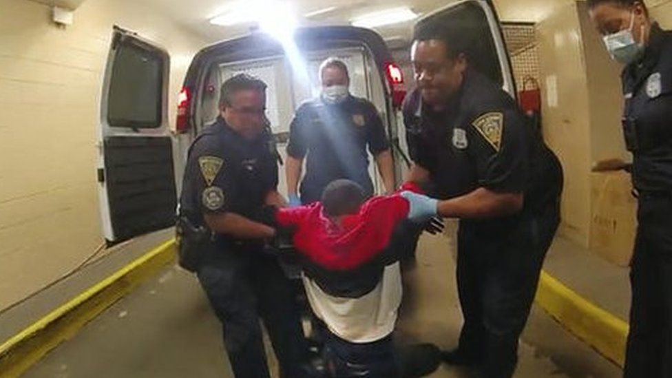 Two officers are seen dragging Randy Cox out of the van by his arms from a still of police body camera video.