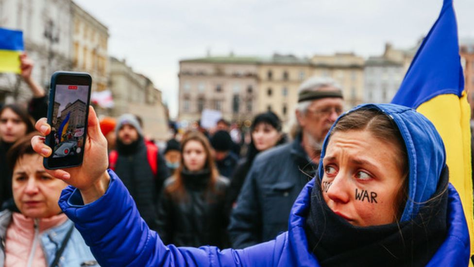 Woman protestor holding up mobile phone