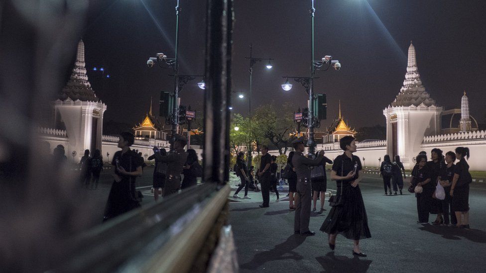Mourners wearing black walk outside the Temple of the Emerald Buddha on October 27 2017
