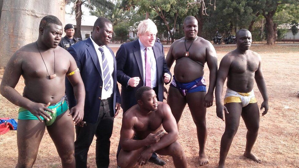 Boris Johnson standing with traditional wrestlers in The Gambia - Tuesday 14 February 2017