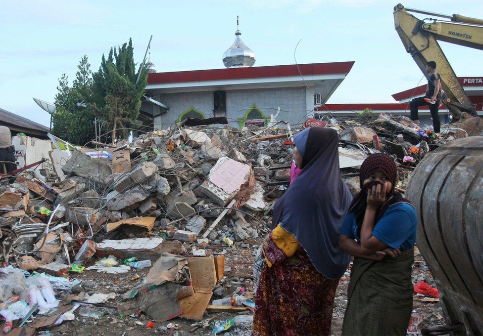 Acehnese women survey the damage after an earthquake in Ulhee Glee, Aceh province, Indonesia, Thursday, 8 December 2016