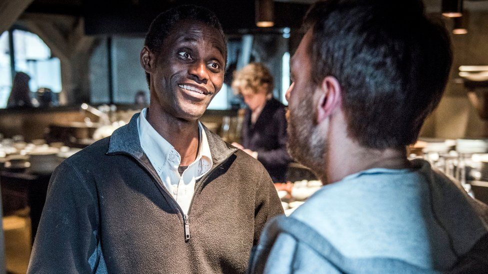 Employee Ali Sonko speaks to a person at the Noma restaurant in Copenhagen, Denmark