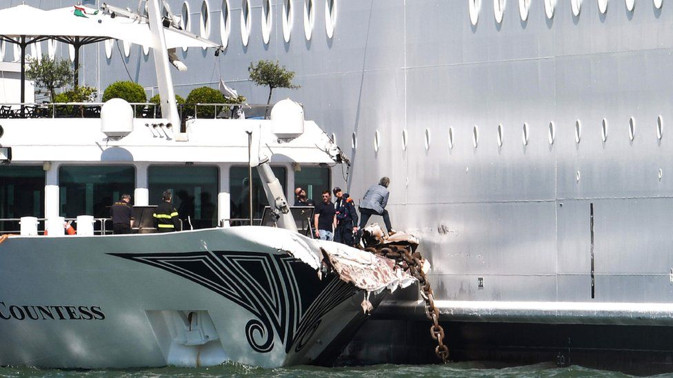 The damaged River Countess tourist boat is pictured after it was hit early on June 2, 2019 by the MSC Opera cruise ship (R) that lost control as it was coming in to dock in Venice, Italy