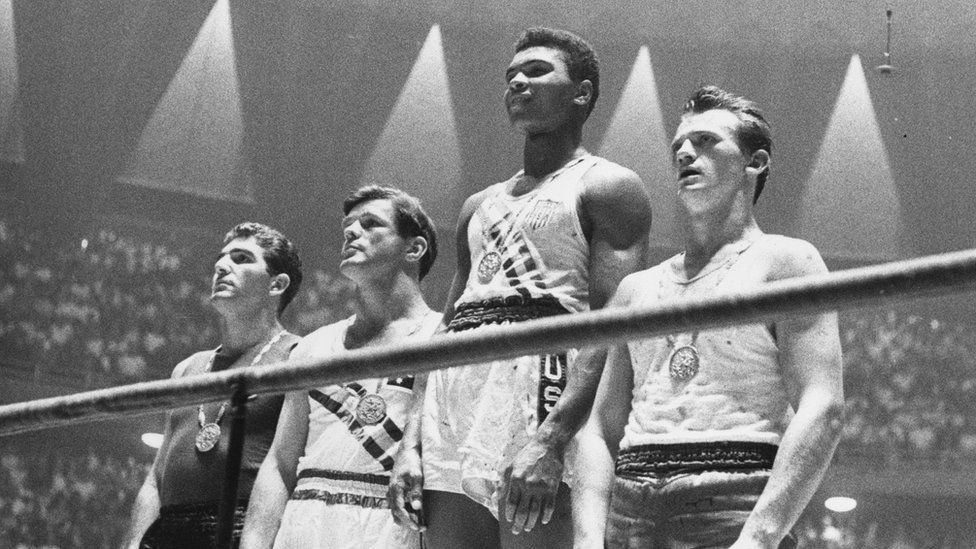 Muhammad Ali receives the gold medal he would later claim to have thrown in the Ohio river because of discrimination in Louisville