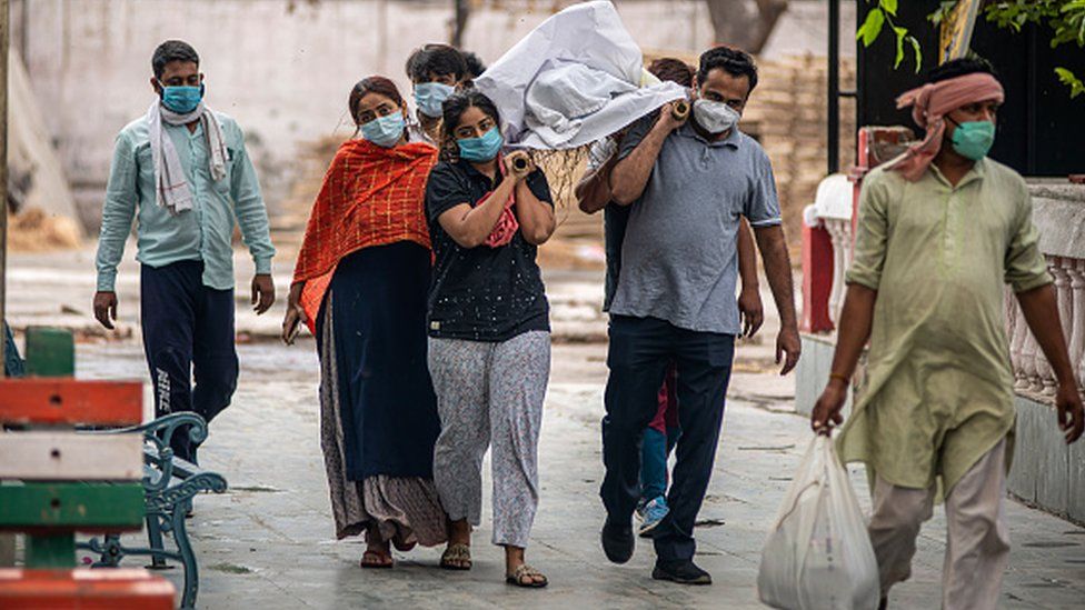 Relatives carry the body of a covid 19 victim at Ghazipur cremation ground on 18 May 2021