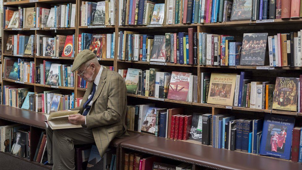 man reading in bookshop