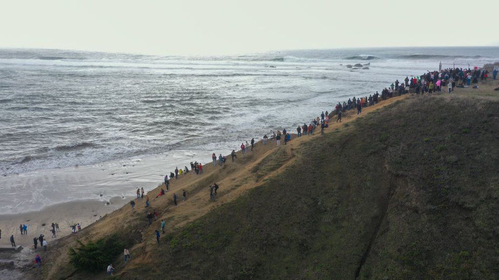 Onlookers climbed the cliffs near Half Moon Bay to get a glimpse of Mavericks