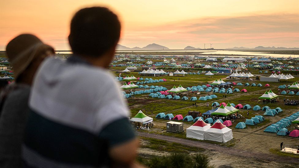 People visit a viewing deck overlooking the campsite of the World Scout Jamboree in Buan, North Jeolla province on August 5, 2023