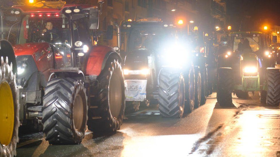 A long line of tractors on a street in Brussels