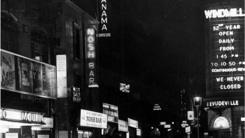 Neon signs of the Windmill Theatre at night in the 1960s