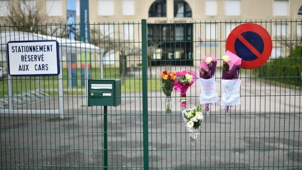 Flowers at the entrance of the school in Crepy-en-Valois, north-east of Paris, where a 60-year-old teacher who died infected with Covid-19 worked