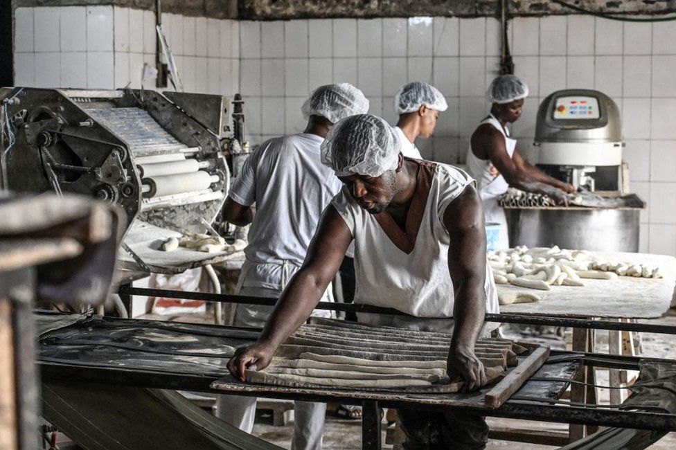 Employees of a bakery make bread with wheat and cassava flour in a bakery in Yopougon, a popular neigbourhood in Abidjan on June 24, 2022